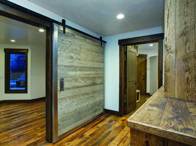 Steel framed barn door built of Nature Aged Wood in a steel frame. Floor is Reclaimed Oak, both by Todd Arenson Construction